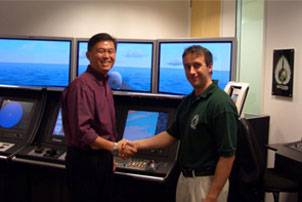 Mark Broster of ECDIS Ltd shaking hands with LTC Terence Ho of the Republic of Singapore Navy. Photo courtesy ECDIS 