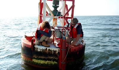 Max Ivanov and Scott Mowery with NOAA's Center for Operational Oceanographic Products and Services install an improved current sensor system on a navigation buoy in Chesapeake Bay. The system transmits real-time current speed and direction observations via satellite to help mariners more safely navigate busy shipping channels. (Photo: NOAA)