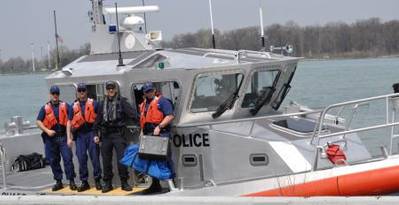 Members of Coast Guard Station Belle Isle in Detroit, and a member of the Royal Canadian Mounted Police pose for a photo on a 45-foot patrol boat after conducting a joint patrol in Lake Erie, May 8, 2014. (USCG Guard photo courtesy of Coast Guard Sector Detroit)