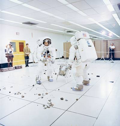 Members of the Apollo 12 lunar landing mission, Charles Conrad Jr. (facing camera) simulates picking up samples, and aAlan L. Bean simulates photographic lunar rock sample documentation, as they participate in lunar surface extravehicular activity (EVA) simulations in the Flight Crew Training Building at the Kennedy Space Center (KSC).  (Photo: Review of U.S. Human Space Flight Plans Committee)