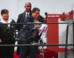 Myrlie Evers-Wilson, the widow of slain civil rights leader Medgar Evers and ship sponsor of Military Sealift Command dry cargo/ammunition ship USNS Medgar Evers, breaks the traditional bottle of champagne against the ship's hull during the ship's christening ceremony Nov. 12 at the General Dynamics NASSCO Shipyard in San Diego. Photo used with permission by Charlie Neuman, San Diego Union Tribune.