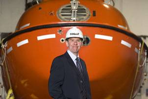 New Cosalt Offshore General Manager Colin Cunningham with a lifeboat supplied by the company. Photo courtesy Think PR ( Scotland) Ltd