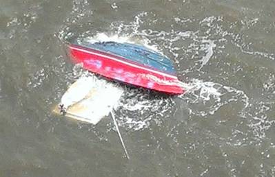 A personal craft is capsized after a collision with a tug and barge Sunday. U.S. Coast Guard photo.