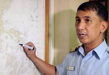 The Philippine coastguard spokesman points to the area on a map where a ferry went down on June 14, 2013 (AFP/File, Jay Directo)