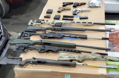 A photo introduced as evidence in the detention hearing for Nihad Al Jaberi includes nine firearms from a shipment interdicted in the Port of Savannah and reassembled, along with other firearms removed during a search of the defendant’s residence. (Photo: U.S. Department of Justice)