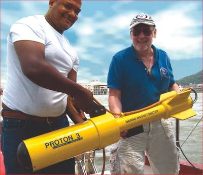 Russell Bennett (r) prepares to survey for shipwreck sites in Panama’s old harbor area with his JW Fishers Proton magnetometer. Presidential Palace is visible in the background between the two men.