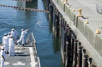 A Sailor aboard the Oliver Hazard Perry-class guided-missile frigate USS Ford (FFG 54) tosses a line as the ship pulls into port at Naval Station Everett. Ford completed her final operational underway and is scheduled for decommissioning October 31. (U.S. Navy photo by Mass Communication Specialist 3rd Class Chris Brown/Released)