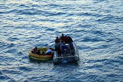 Sailors from the guided-missile destroyer USS John S. McCain (DDG 56) pull sailors from the Republic of Korea (ROK) commercial fishing boat M/V Je 2 Bong Ho into a Rigid Hull Inflatable Boat. The ROK sailors abandoned their vessel after it caught fire. U.S. Navy photo by Chief Intelligence Specialist Thomas Fischer 