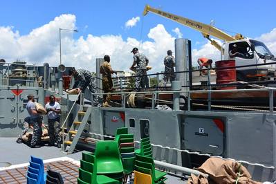 Sailors from HMAS Tarakan load supplies donated by the Rotary Club of Honiara onto their ship during a port visit to Honiara, Solomon Islands. Photo: Craig Blakely