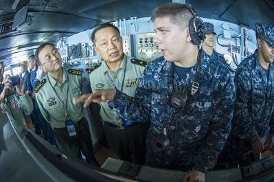 Seaman Alex Snyder, right, explains the functions of the helm on the navigation bridge of the aircraft carrier USS George Washington to Maj. Gen. Chen Weizhan, deputy commander of the People's Liberation Army, Hong Kong Garrison, center, and Col. Li Jiandang, Hong Kong Garrison liaison officer during a distinguished visitor embark. (U.S. Navy photo by Ricardo R. Guzman)
