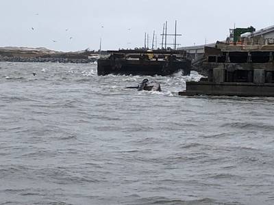 The semi-submerged tugboat Miss Bonnie sits in the water after alliding with the Old Bonner Bridge in Oregon Inlet, North Carolina. (U.S. Coast Guard photo courtesy of Coast Guard Station Oregon Inlet)