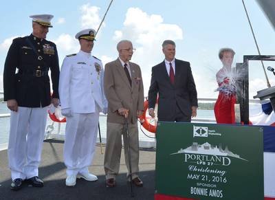 Ship Sponsor Bonnie Amos christens Portland (LPD 27), accompanied by (left to right) U.S. Marine Corps Maj. Gen. Christopher Owens, director of the U.S. Navy’s expeditionary warfare division; Capt. Jeremy Hill, prospective commanding officer, Portland; Ted Waller, a World War II veteran who served on the first USS Portland (CA 33); and Brian Cuccias, president of Ingalls Shipbuilding. Portland is the 11th LPD to be built by Ingalls. (Photo by Lance Davis/HII)