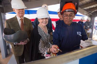 Ship Sponsor Kay Webber Cochran (center) sketches her initials onto the keel plate of the National Security Cutter Kimball (WMSL 756). Also pictured are her husband, Sen. Thad Cochran (left), R-Miss., and Ingalls Shipbuilding employee Jerry Wesley (right), who welded the initials onto the plate. Photo by Lance Davis/HII