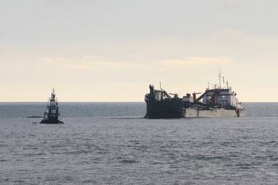 A split-hull trailing suction hopper dredge, linked to a tugboat, operates Jan. 31 off the shore of Solana Beach, Calif. (Photo: Stephen Baack / USACE)