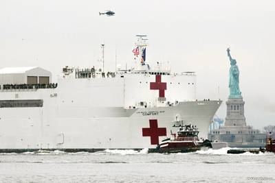 The Capt. Brian A. McAllister leads the way for the USNS COMFORT into NY Harbor as she passes the Statue of Liberty on March 30, 2020. (Photo Credit: Max Guliani)