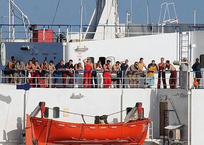 The crew of the merchant vessel MV Faina stands on the deck after a U.S. Navy request to check on their health and welfare. The Belize-flagged cargo ship, owned and operated by Kaalybe Shipping, Ukraine, was seized by pirates Sept. 25 and forced to proceed to anchorage off the Somali Coast. The ship is carrying a cargo of Ukrainian T-72 tanks and related military equipment. U.S. Navy photo by Mass Communication Specialist 2nd Class Jason R. Zalasky.