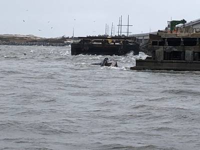 The semi-submerged tugboat Miss Bonnie sits in the water after alliding with the Old Bonner Bridge in Oregon Inlet, North Carolina. (U.S. Coast Guard photo courtesy of Coast Guard Station Oregon Inlet)