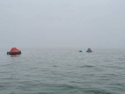 The stern of Pappy's Pride appears above the waterline beside the vessel's inflatable life raft after a collision in Galveston, Texas. Coast Guard crews continue to search for two of the four crew members aboard after a collision between the fishing vessel and chemical tanker Bow Fortune. (U.S. Coast Guard photo by Station Galveston)