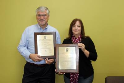 Tom Johnson, President, and Merralee Burr, HS&E Management Representative, hold BMT Scientific Marine Services plaques for ISO 14001:2004 and OHSAS 18001:2007 certification.