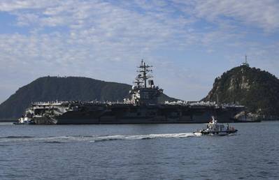 Tugboats prepare to maneuver the U.S. Navy’s only forward-deployed aircraft carrier USS Ronald Reagan (CVN 76) to port in Busan, Republic of Korea, Sept. 23. (Photo: Leon Wong / U.S. Navy)