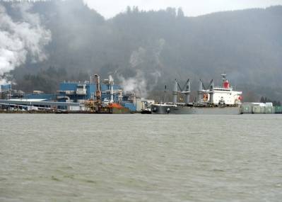 Two tugs support Sparna past the Wauna Paper Mill while in transit along the Columbia River to their mooring destination in Kalama, Wash., March 23, 2016. (U.S. Coast Guard photo by Levi Read)