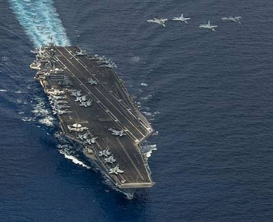 US and Malaysian jets fly above the aircraft carrier USS Carl Vinson in the South China Sea. The Carl Vinson Strike group is deployed to 7th Fleet area of operations supporting security and stability in the Indo-Asia-Pacific region. (U.S. Navy photo by John Philip Wagner, Jr.)