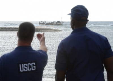 U.S. Coast Guard personnel discuss future operations for the removal of product aboard the commercial fishing vessel Chui Zai Fa No. 1 grounded about 300-yards off Leone Bay (U.S. Coast Guard photo by Tara Molle)