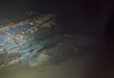 Wooden boat that smashed apart on rocks off southern Italy on Sunday - Credit: Italian Coast Guard - Screenshot