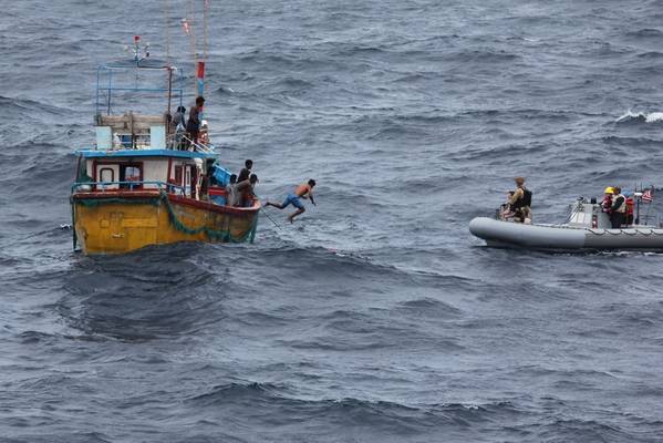 Рыбак Шри-Ланки прыгает и плавает на надувной лодке с жестким корпусом из эскадренного миноносца управляемой ракеты Arleigh Burke USS Decatur (DDG 73) после того, как корабль остановился, чтобы оказать помощь рыболовецкому судну. (Фото ВМС США)
