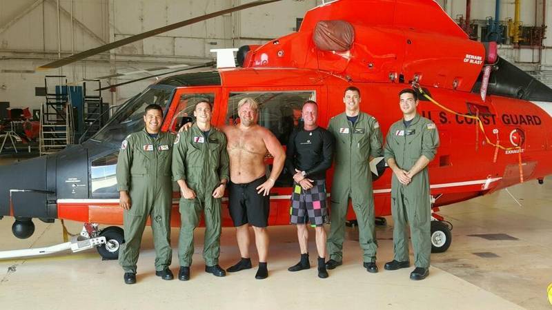 A Coast Guard Air Station Corpus Christi MH-65 Dolphin helicopter aircrew stands with two rescued divers after they were located and rescued Saturday, June 27. (U.S. Coast Guard photo)