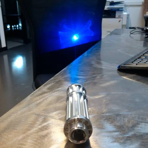 A high-powered blue laser shines against a black background, demonstrating just how strong the light can be when emitted from this device. (Photo: U.S. Coast Guard)