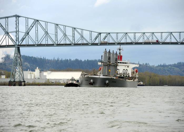 A pair of tugs support the 623-foot motor vessel Sparna under the Lewis and Clark Bridge while transiting to a pier in Kalama,Wash., March 23, 2016. A small boat crew from Coast Guard Station Portland also escorted the Sparna enforcing a 100-yard safety zone. (U.S. Coast Guard photo by Levi Read.)