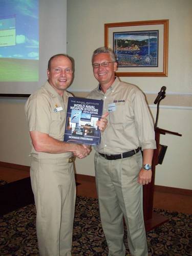 Ted Ackerstierna, Ted Ackerstierna, head of naval domain marketing and sales for Saab Electronic Defence Systems thanks Captain Winton Smith, commanding officer of the U.S. Naval Base at San Diego, Calif., which served as the host for the 2012 Sea Giraffe Users Group. Ackerstierna presented a signed copy of Naval Institute Guide to World Naval Weapon Systems by Dr. Norman Friedman. Dr. Friedman was the keynote speaker for the first day of the three day Sea Giraffe User Group workshop. (Photo
