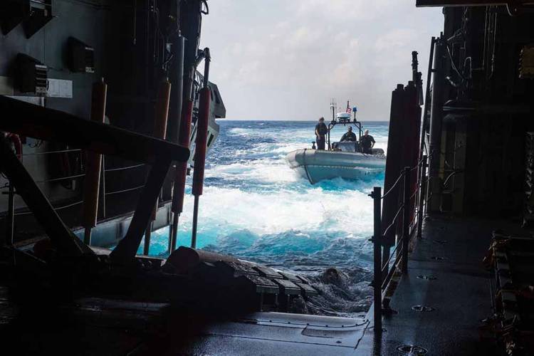 An 11 meter rigid hull inflatable boat (RHIB) approaches the open stern doors of the water borne mission zone aboard the USS Fort Worth (LCS 3). (U.S. Navy photo by Mass Communication Specialist 2nd Class Antonio Turretto Ramos)