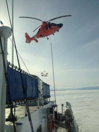 An MH-65C Dolphin helicopter crew from Coast Guard Air Station Traverse City, Mich., conducts hoist training operations with the crew of Coast Guard Cutter Katmai Bay Feb. 5, 2014. (U.S. Coast Guard photo by Seaman James Ash)