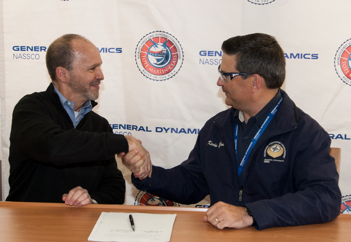 Anthony Chiarello, president and CEO of TOTE, and Kevin Graney, vice president and general manager at General Dynamics NASSCO, shake hands following delivery signing ceremony aboard the Perla Del Caribe at the NASSCO shipyard. (Photo: General Dynamics NASSCO)