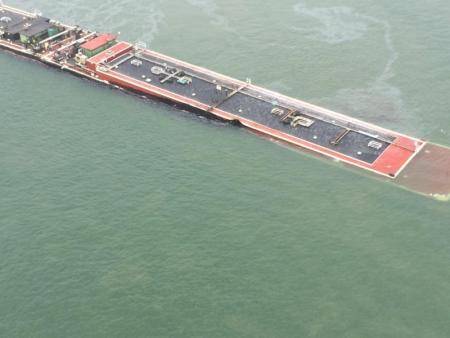 A barge loaded with marine fuel oil sits partially submerged in the Houston Ship Channel, March 22, 2014.