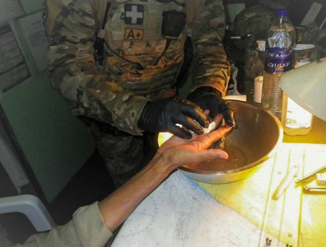 Boarding team supporting crew member with first aid on board MV Costina (Photo: EU NAVFOR)