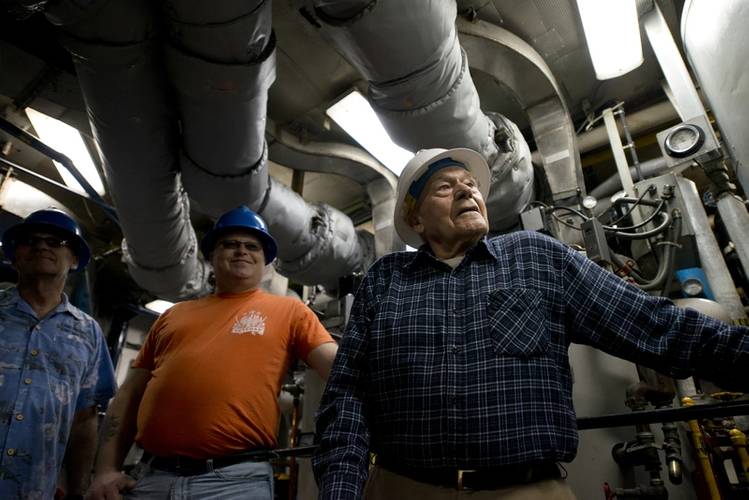 Briggs and two of his sons tour the engine room of the Eagle, where Briggs spent most of his time underway. (Photo: Jasmine Mieszala)