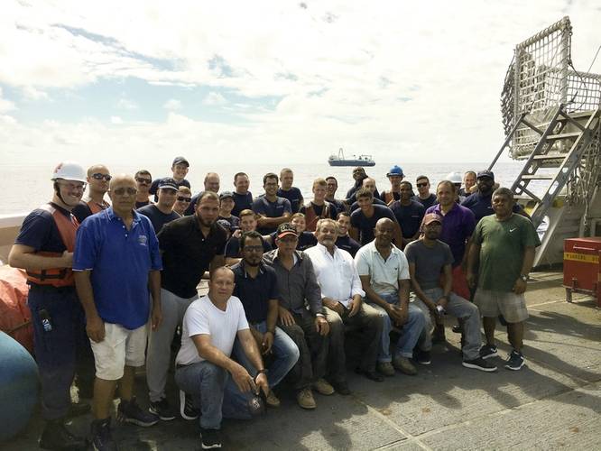 Some of Coast Guard Cutter Confidence's crew gathers with men rescued from the cargo ship Alta. (U.S. Coast Guard photo by Todd Behney)