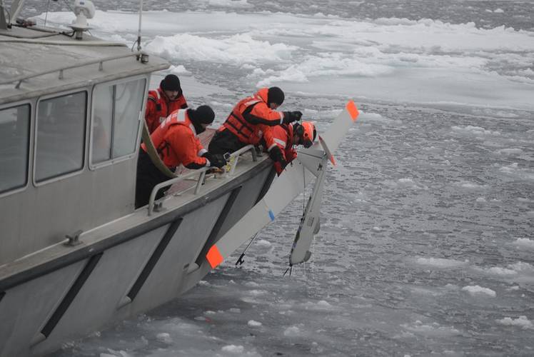 Coast Guard Cutter Healy small boat crew members retrieve a National Oceanic and Atmospheric Administration small unmanned aircraft system after it landed in icy water. The SUAS was used to identify simulated spilled oil so that deployable recovery systems could be utilized. (U.S. Coast Guard photo by Petty Officer 3rd Class Grant DeVuyst)