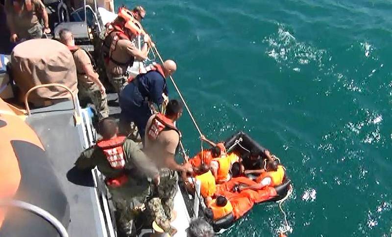 Coast Guardsmen from U.S. Coast Guard Cutter Maui rescue five Iranian mariners after they were found adrift in a life raft. U.S. Navy video capture.