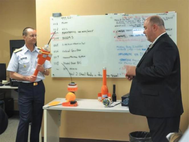 Vice Commandant of the Coast Guard, Adm. Charles Michel, inspects a Maritime Object Tracker Technology (MOTT) while Tim Hughes explains the history and capabilities of the device, during a technology demonstration at Coast Guard Research and Development Center, Thursday, Feb. 15, 2018, in New London, Connecticut. (U.S. Coast Guard Photo courtesy of Research and Development Center)