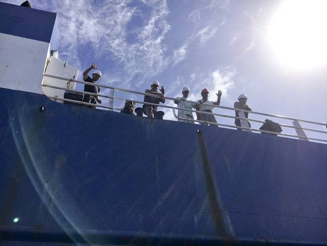 The crew of the disabled cargo ship Alta welcomes the Coast Guard Cutter Confidence's small boat crew as they arrive on scene on October 7. (U.S. Coast Guard photo by Samantha Penate)