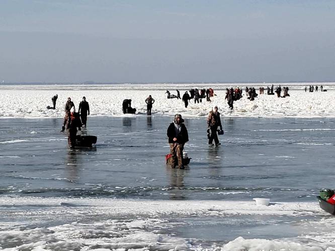 Ice fishermen walk to land after being stuck on an ice floe that broke free from land north of Catawaba Island, March 9, 2019. 46 people were rescued by Coast Guard and local agencies via airboats and approximately 100 people were able to self-rescue by walking across ice-bridges or swimming in the water. (U.S. Coast Guard Photo)