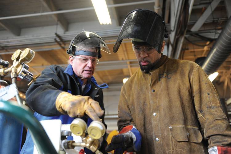 Instructor Mike Rasmussen working with student at the Swan Island Training Center in Portland. (Photo credit: Vigor Industrial)