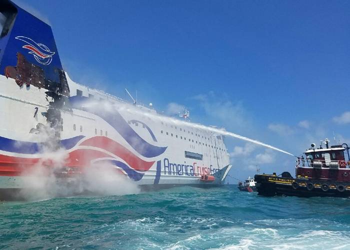 A local Puerto Rico-based tug crew use a fire hose to cool the hull of the Caribbean Fantasy, Wednesday, August 17, 2016. (U.S. Coast Guard photo courtesy of Station San Juan, Puerto Rico)