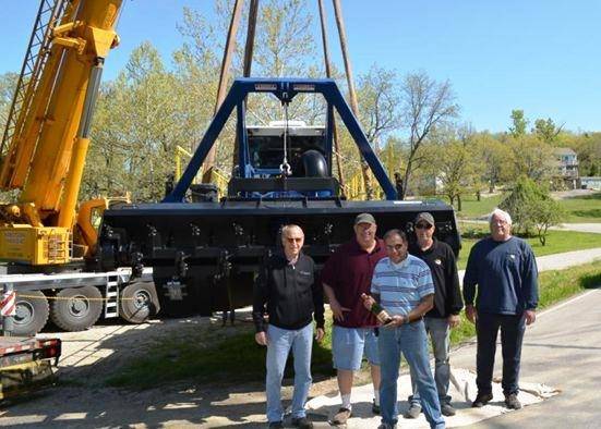 Preparing to christen their new 2015 Model 7012 HP Versi-Dredge with champagne. Left to right: Terry Haug, Association President; Jan Olson, Executive Director; David Wagner, Dredge Committee Chairperson; Greg Rudder, Operations Manager and Monte McLin, Dredge Operator/Mechanic  (Photo: IMS)