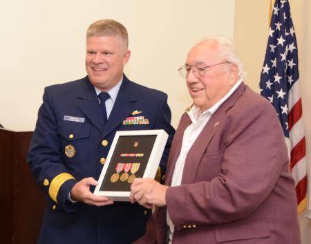 Rear Adm. Fred Midgette (left) presents World War II veteran Phillip Sustersic with awards he earned while serving in the Merchant marines nearly 70 years ago. U.S. Coast Guard photo by Petty Officer 3rd Class Christopher M. Yaw