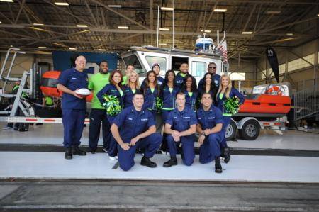 Rear Adm. Richard Gromlich (left), commander of the Coast Guard 13th District, poses with Seattle Seahawk football players and cheerleaders, and a boatcrew from Coast Guard Station Seattle, in front of a 25-foot Response Boat (USCG photo by Katelyn Shearer)